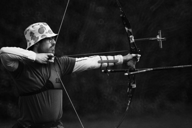 Archer drawing a compound bow with an arrow at full draw