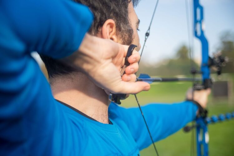Close-up of an archer positioning fingers on the bowstring