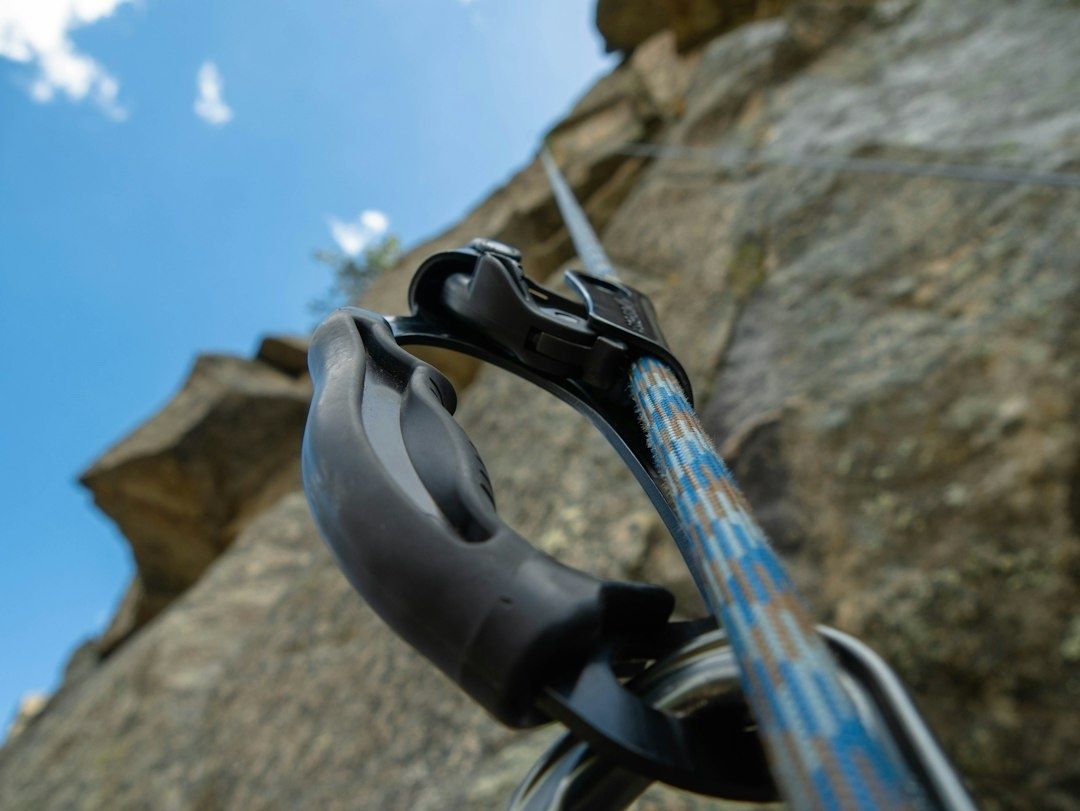 Close-up of an archery release aid and bowstring against a rock wall